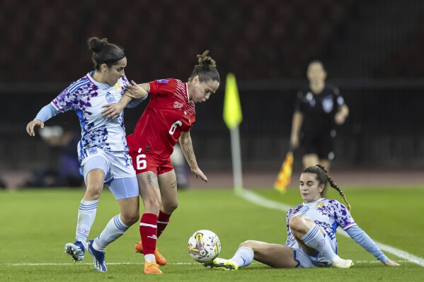 Switzerland's midfielder Geraldine Reuteler, center, fights for the ball with Spain's defender Oihane Hernandez, left, and Spain's midfielder Teresa Abelleira, right, during the Nations League women's soccer match between Switzerland and Spain at the Letzigrund stadium in Zurich, Switzerland, on Tuesday, Oct. 31, 2023. (Michael Buholzer/Keystone via AP)