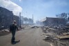 FILE - In this photo provided by Tiffany Kidder Winn, a man walks past wildfire damage, Wednesday, Aug. 9, 2023, in Lahaina, Hawaii. (Tiffany Kidder Winn via AP, File)