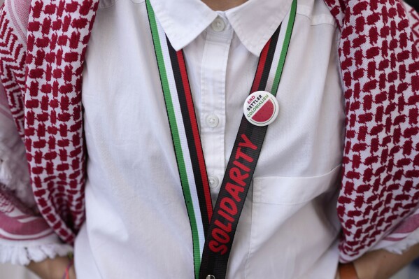 A protester wearing a pin with a watermelon symbol takes part in a demonstration calling for a ceasefire in the Israel-Hamas war at the COP28 UN climate summit in Dubai, United Arab Emirates on Sunday, December 3, 2023.  (AP Photo/Rafiq Maqbool, File)