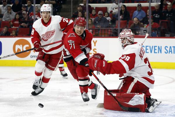 Carolina Hurricanes' Jesper Fast (71) chases the puck between Detroit Red Wings goaltender Alex Nedeljkovic (39) and Gustav Lindstrom (28) during the second period of an NHL hockey game in Raleigh, N.C., Tuesday, April 11, 2023. (AP Photo/Karl B DeBlaker)