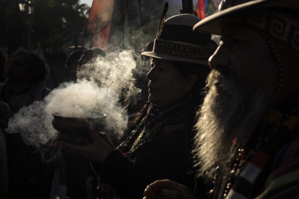 Indigenous leaders from the province of Jujuy burn incense during the celebrations of "La Pachamama," or Mother Earth Day in Buenos Aires, Argentina, Tuesday, Aug. 1, 2023. The group's protest that coincides with "La Pachamama Day" is also directed against a provincial constitutional reform they claim is an attempt against their ancestral rights to lands that the state aims to use for lithium mining. (AP Photo/Rodrigo Abd)