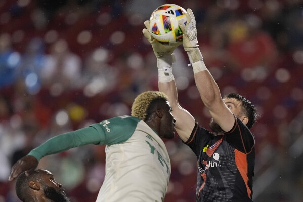 FC Dallas goalkeeper Maarten Paes, right, makes a save against Austin FC forward Gyasi Zardes, second from right, during the second half of an MLS soccer match Saturday, May 11, 2024, in Frisco, Texas. (AP Photo/LM Otero)