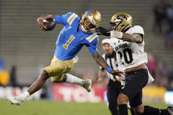 UCLA quarterback Dorian Thompson-Robinson (1) jumps next to Colorado linebacker Robert Barnes during the first half of an NCAA college football game Saturday, Nov. 13, 2021, in Pasadena, Calif. (AP Photo/Marcio Jose Sanchez)