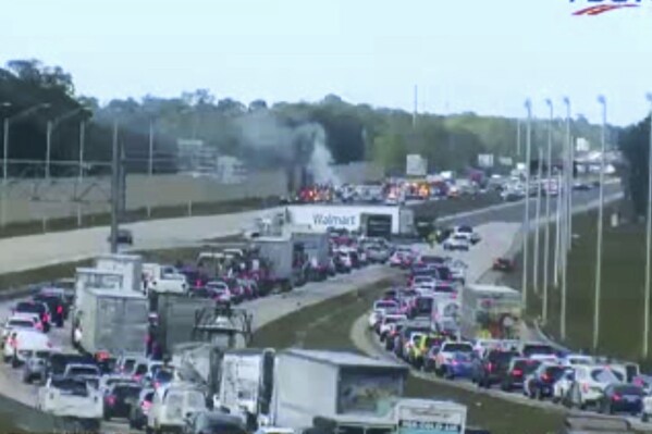 In this image provided by the Florida Department of Transportation, Florida Highway Patrol troopers are on the scene of a small airplane landing on southbound Interstate 75 in Naples, Fla., Friday, Feb. 9, 2024. The plane collided with a vehicle as it made the emergency landing. (Florida DOT/The News-Press via AP)