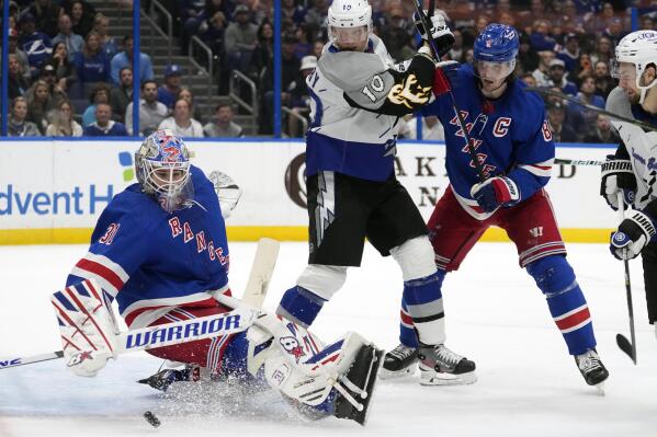 New York Rangers goaltender Igor Shesterkin (31) makes a sliding save as defenseman Jacob Trouba (8) keeps Tampa Bay Lightning right wing Corey Perry (10) from a rebound during the second period of an NHL hockey game Thursday, Dec. 29, 2022, in Tampa, Fla. (AP Photo/Chris O'Meara)