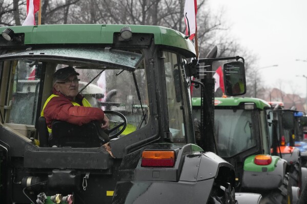 Polish farmers, angry at EU agrarian policy and cheap Ukraine produce imports which, they say, are undercutting their livelihoods, drive their heavy-duty tractors in protest outside the office of the regional governor, in Poznan, western Poland, Friday Feb. 9, 2024. (AP Photo/Czarek Sokolowski)