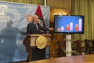 Arkansas Gov. Asa Hutchinson stands next to a chart displaying COVID-19 hospitalization data as he speaks at a news conference at the state Capitol in Little Rock, Ark., Thursday, July 29, 2021. Hutchinson announced he was calling a special session to take up a proposal to lift the state’s ban on face mask mandates in public schools. (AP Photo/Andrew DeMillo)