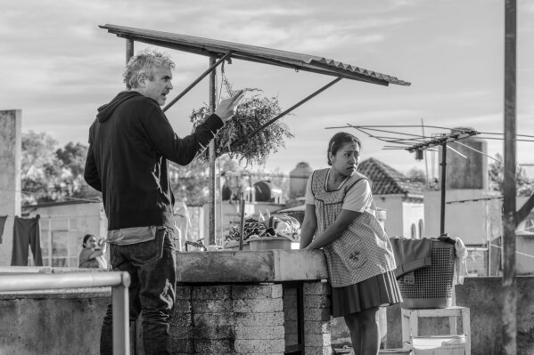 
              This image released by Netflix shows filmmaker Alfonso Cuaron, left, and actress Yalitza Aparicio on the set of "Roma."  Cuaron’s “Roma” has dominated the New York Film Critics Circle Awards, winning best film, best director and best cinematography. The film is Netflix’s most acclaimed release yet, and it’s widely expected to contend for best picture at the Academy Awards. (Carlos Somonte/Netflix via AP)
            