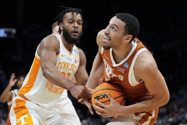 Texas forward Dylan Disu, right, drives to the basket past Tennessee guard Josiah-Jordan James during the first half of a second-round college basketball game in the NCAA Tournament, Saturday, March 23, 2024, in Charlotte, N.C. (AP Photo/Chris Carlson)