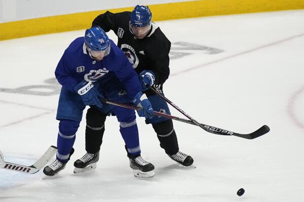 Colorado Avalanche right wing Mikko Rantanen (96) and defenseman Jack Johnson (3) battle for the puck during an NHL hockey practice, ahead of Game 2 of the Stanley Cup Finals, Friday, June 17, 2022, in Denver. (AP Photo/John Locher)