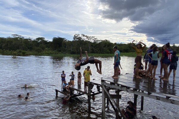 FILE - Kids play in Atalaia do Norte, Amazonas state, Brazil, March 1, 2023. Scores of Indigenous families have left their territory in the Javari Valley, for the impoverished city of Atalaia do Norte, some in pursuit of a better education and drawn by a federal benefit that can ensnare them in the city. (AP Photo/Fabiano Maisonnave, File)