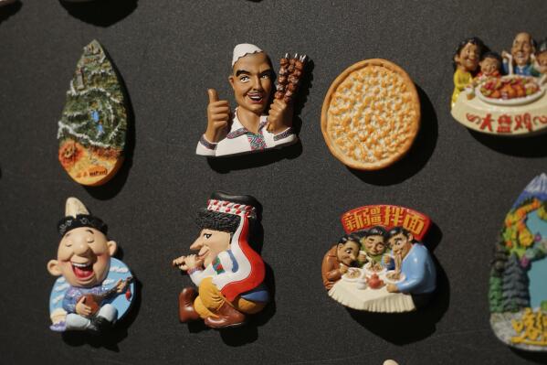 Uyghur-themed fridge magnets are displayed at a naan museum in Urumqi, the capital of China's far west Xinjiang region, on April 21, 2021. Four years after Beijing's brutal crackdown on largely Muslim minorities native to Xinjiang, Chinese authorities are dialing back the region's high-tech police state and stepping up tourism. But even as a sense of normality returns, fear remains, hidden but pervasive. (AP Photo/Dake Kang)