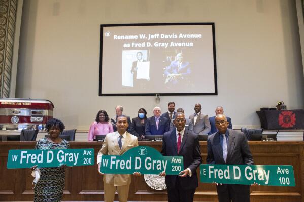 Mayor Steven Reed poses for photos with Fred Gray Jr. and Stanley Gray after city council voted unanimously to rename Jeff Davis Ave. after, Gray's father, civil rights attorney Fred Gray at City Hall in Montgomery, Ala., on Tuesday, Oct. 5, 2021. (Jake Crandall/The Montgomery Advertiser via AP)