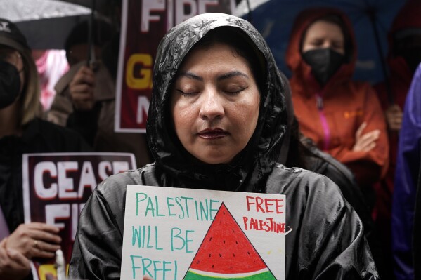 FILE - People participate in a sit-in demanding a cease-fire in the Israel-Hamas war at De Longpre Park in Los Angeles, Wednesday, Nov. 15, 2023. Over the past three months, on banners and T-shirts and balloons and social media posts, one piece of imagery has emerged around the world in protests against the Israel-Hamas war: the watermelon. The fruit has increasingly come to be recognized as a symbol of Palestinian resistance and a global sign of solidarity. (AP Photo/Damian Dovarganes, File)