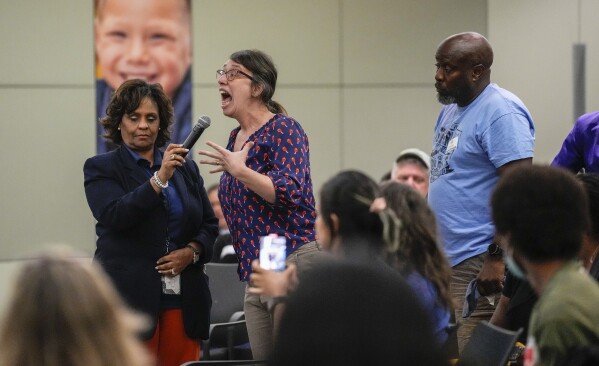 A teacher speaks as Houston Independent School District Superintendent Mike Miles answers questions during a community meeting at the Hattie Mae White HISD building on Tuesday, July 18, 2023, in Houston. The largest school district in Texas is opening a new chapter as the state takes over Houston’s public school district. (Karen Warren/Houston Chronicle via AP)