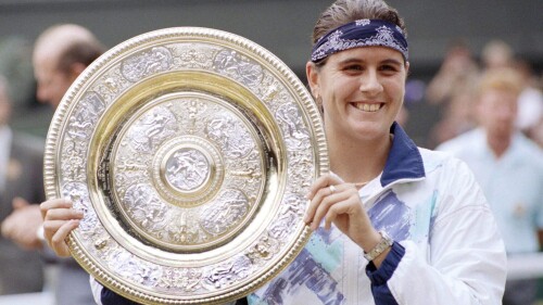 FILE - Conchita Martinez holds up the trophy after winning the Ladies Singles Final on the Centre Court at Wimbledon, July 2, 1994. Former Wimbledon champion Conchita Martínez has been named tournament director for the Billie Jean King Cup finals. Twelve national teams will play in Seville during the finals from Nov. 7-12. (AP Photo/Dave Caulkin, File)