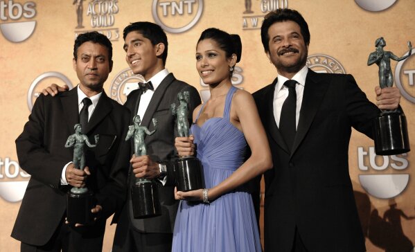 FILE - In this Jan. 25, 2009 file photo, members of the cast of "Slumdog Millionaire," from left, Irrfan Khan, Dev Patel, Freida Pinto and Anil Kapoor, pose backstage with the award for outstanding performance by a cast in a motion picture during the 15th Annual Screen Actors Guild Awards in Los Angeles. Khan, a veteran character actor in Bollywood movies and one of India's best-known exports to Hollywood, died Wednesday, April 29, 2020, after being admitted to Mumbai’s Kokilaben Dhirubhai Ambani hospital with a colon infection. He was 54. (AP Photo/Chris Pizzello, File)