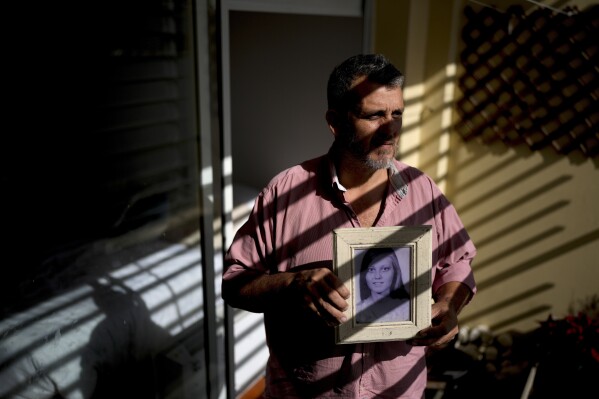 Pedro Alejandro Sandoval holds a photo of his biological mother Liliana Fontana, in Buenos Aires, Argentina, Monday, Aug. 7, 2023. Sandoval is one of the 133 “recovered grandchildren” of Argentina. (AP Photo/Natacha Pisarenko)
