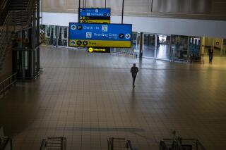 FILE - A man walks through a deserted part of Johannesburg's OR Tambo's airport, South Africa, Monday Nov. 29, 2021. As countries shut their doors to foreign tourists or reimpose restrictions because of the new omicron variant of the coronavirus, tourism that was just finding it's footing again could face another major pandemic slowdown amid the uncertainty about the new strain. (AP Photo/Jerome Delay, File)