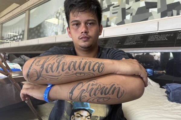 Richy Palalay, who was born and raised in the Hawaii town of Lahaina on the island of Maui, shows his "Lahaina Grown" tattoo at an evacuation shelter in Wailuku, Hawaii, Saturday, Aug. 12, 2023. There's concern that any homes rebuilt after a wildfire that tore through Lahaina will be targeted not at homegrown residents who give the town its spirit and identity but instead affluent outsiders seeking a tropical haven. That would turbo-charge what is already one of Hawaii's gravest and biggest challenges: the exodus and of Native Hawaiian and local-born residents who can no longer afford to live in their homeland. (AP Photo/Audrey McAvoy)