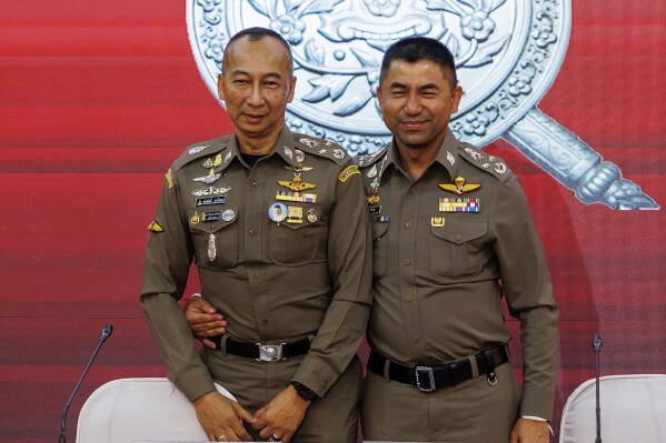 FILE - Chief Royal Thai Police Torsak Sukvimol, left, Duputy Chief the royal Thai Police Surachate Hakparn, embrace after a press conference in Bangkok, Thailand, on March 20, 2024. A deputy chief of Thailand’s national police force involved in many high-profile cases turned himself in to fellow officers on Tuesday April 2, 2024 after a court issued a warrant for his arrest on money laundering charges. Police Gen. Surachate Hakparn had recently been suspended from his duties due to his involvement in infighting among the department’s top ranks. (AP Photo/Pirun Nanta, File)