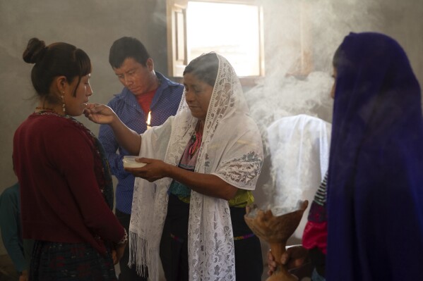 Crecencia López, wife of Deacon Juan Pérez Gómez, offers Communion wafers during a Mass honoring the late Pope Francis, in the Simojovel municipality, Mexico, April 27, 2025. (AP Photo/Isabel Mateos, File)