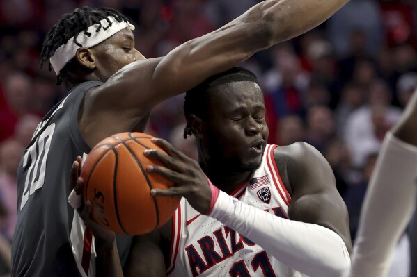 Washington State center Rueben Chinyelu (20) defends against Arizona center Oumar Ballo (11) under the basket during the first half of an NCAA college basketball game Thursday, Feb. 22, 2024, in Tucson, Ariz. (Kelly Presnell/Arizona Daily Star via AP)