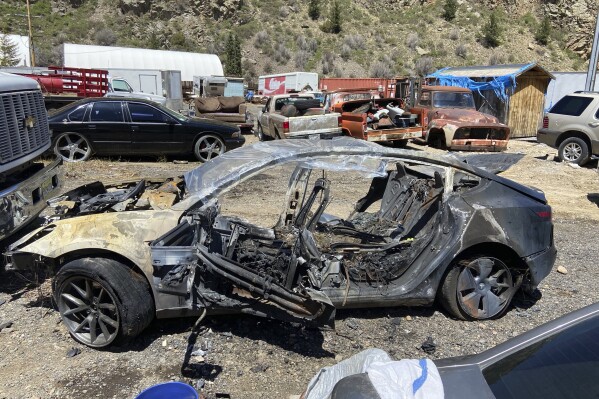 This image provided by Colorado State Patrol shows a Tesla Model 3 that crashed on May 16, 2022 in Clear Creek County, Colo. The widow of a man who died after his Tesla veered off the road and crashed into a tree while he was using its partially automated driving system in Colorado in 2022 is suing the car maker, claiming its marketing of the technology is dangerously misleading. The Autopilot system prevented Hans Von Ohain from being able to keep his Model 3 Tesla on the road and he died after the car burst into flames after hitting the tree, according to the lawsuit filed by Nora Bass in Colorado state court on May 3, 2024. A passenger was able to escape, it said. (Colorado State Patrol via AP)