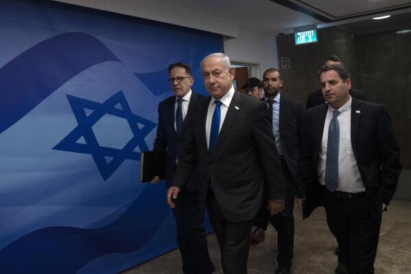 Israel's Prime Minister Benjamin Netanyahu, center, arrives to chair the weekly cabinet meeting in Jerusalem, Sunday, March 12, 2023. (AP Photo/Maya Alleruzzo, Pool)