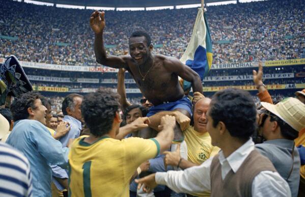FILE - Brazil's Pele is hoisted on the shoulders of his teammates after Brazil won the World Cup final against Italy, 4-1, in Mexico City's Estadio Azteca, June 21, 1970. Pelé, the Brazilian king of soccer who won a record three World Cups and became one of the most commanding sports figures of the last century, died in sao Paulo on Thursday, Dec. 29, 2022. He was 82. (AP Photo, File)