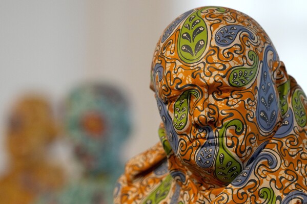 A fiberglass and hand-painted sculpture of Winston Churchill by artist Yinka Shonibare is on display during a photo call for his Suspended States exhibition, at Serpentine South in London, April 11, 2024. (AP Photo/Frank Augstein)