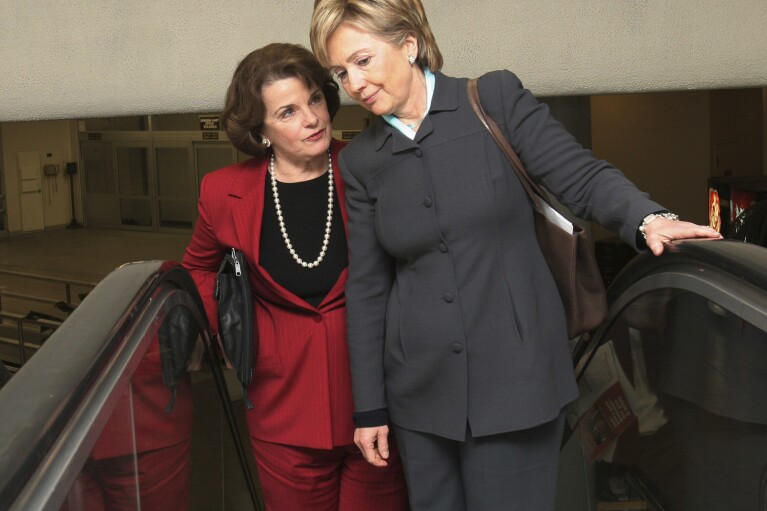 FILE - Sen. Hillary Rodham Clinton, D. N.Y., right, talks with Sen. Dianne Feinstein, D-Calif., on their way to vote on the Deficit Reduction Act, Wednesday, Dec. 21, 2005, on Capitol Hill in Washington. (AP Photo/Lauren Victoria Burke, File)