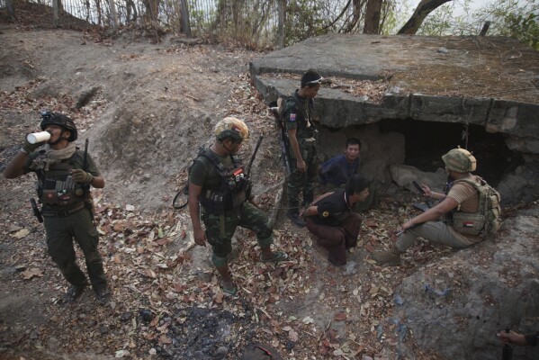 FILE - Members of the Karen National Liberation Army and People's Defense Force examine two arrested soldiers after they captured an army outpost, in the southern part of Myawaddy township in Kayin state, Myanmar, March 11, 2024. Six months into an offensive against Myanmar’s military administration, opposition forces have made massive gains, but civilian casualties are rising sharply as regime troops increasingly turn toward scorched-earth tactics in the Southeast Asian country's bitter civil war. (AP Photo/METRO, File)