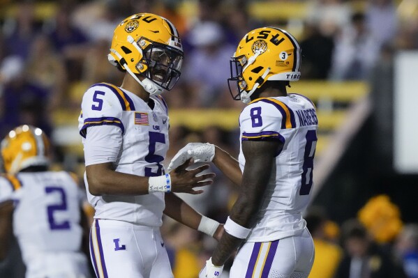 LSU wide receiver Malik Nabers (8) celebrates his touchdown reception with quarterback Jayden Daniels (5) in the first half of an NCAA college football game against Army in Baton Rouge, La., Saturday, Oct. 21, 2023. (AP Photo/Gerald Herbert)