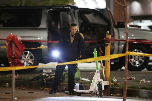 Denver Police Department investigators work the scene of a mass shooting early Tuesday, June 13, 2023, in Denver. Police say several people were wounded in an area where basketball fans had been celebrating the Denver Nuggets first NBA title win. A man who is a suspect was one of the people shot and was taken into custody.(AP Photo/David Zalubowski)