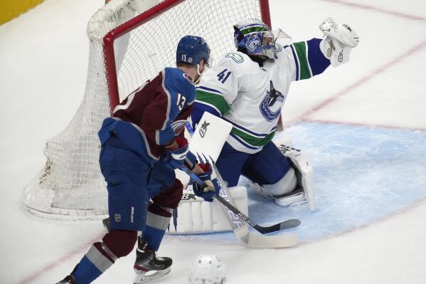 Vancouver Canucks goaltender Jaroslav Halak, right, makes a glove save as Colorado Avalanche right wing Valeri Nichushkin watches during the first period of an NHL hockey game Wednesday, March 23, 2022, in Denver. (AP Photo/David Zalubowski)