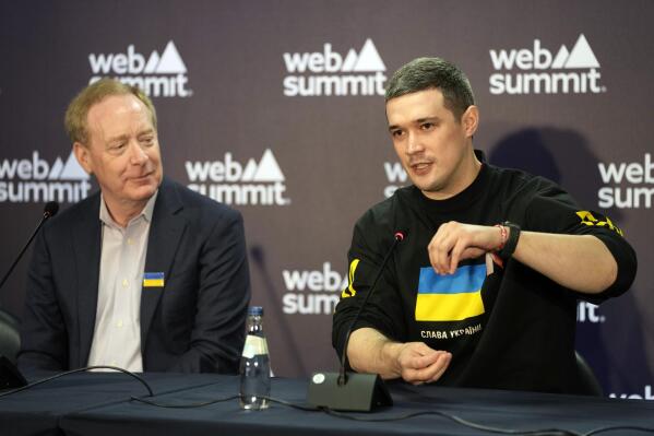 Ukraine's Minister of Digital Transformation Mykhailo Fedorov gestures during a joint news conference with President and Vice Chairman of Microsoft Brad Smith, left, at the Web Summit technology conference in Lisbon, Portugal, Thursday, Nov. 3, 2022. (AP Photo/Armando Franca)