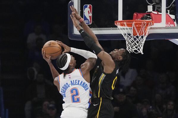 Oklahoma City Thunder guard Shai Gilgeous-Alexander (2) shoots as Golden State Warriors guard Donte DiVincenzo, right, defends in the first half of an NBA basketball game Tuesday, March 7, 2023, in Oklahoma City. (AP Photo/Sue Ogrocki)