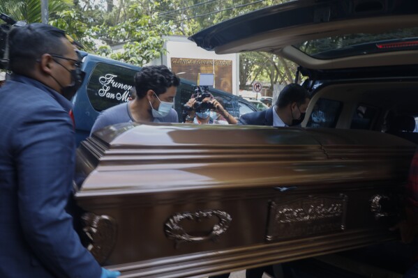 Funeral home workers place a coffin containing the remains of a female inmate, into a hearse in Tegucigalpa, Honduras, Wednesday, June 21, 2023. A riot on Tuesday at a women's prison northwest of the Honduran capital left at least 46 inmates dead, many of them burned, shot or stabbed to death, a Honduran police official said. (AP Photo/Elmer Martinez)