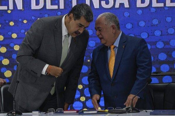 Venezuela's President Nicolas Maduro, left, speaks with National Electoral Council President Elvis Hidrobo Amoroso during the notification ceremony for the referendum about the future of a disputed territory with Guyana, in Caracas, Venezuela, Monday, Dec. 4, 2023. (APPhoto/Ariana Cubillos)