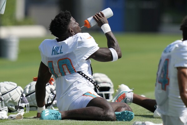 Miami Dolphins wide receiver Tyreek Hill (10) takes a drink during the NFL football team's training camp Monday, July 29, 2024, in Miami Gardens, Fla. (AP Photo/Lynne Sladky)