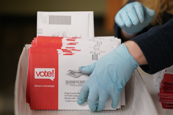 FILE - Erik Thurston prepares ballots from a drop box for the sorting machines on Election Day at the King County Elections headquarters, Nov. 7, 2023, in Renton, Wash. The Washington state Senate has voted Thursday, Feb. 22, 2024 to make harassing election workers a felony. The decision comes three months after several county election offices received envelopes containing suspicious powders and had to be evacuated. (AP Photo/Lindsey Wasson, file)