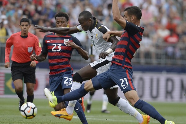 FILE - United States' Kellyn Acosta, left, and Matt Hedges, right, pressure Ghana's Raphael Dwamena, center, during the first half of an international friendly soccer match at Pratt & Whitney Stadium at Rentschler Field, Saturday, July 1, 2017, in East Hartford, Conn. Former Ghana striker Raphael Dwamena has died after collapsing Saturday, Nov. 11, 2023, during an Albanian Super League soccer match. (AP Photo/Jessica Hill, FIle)