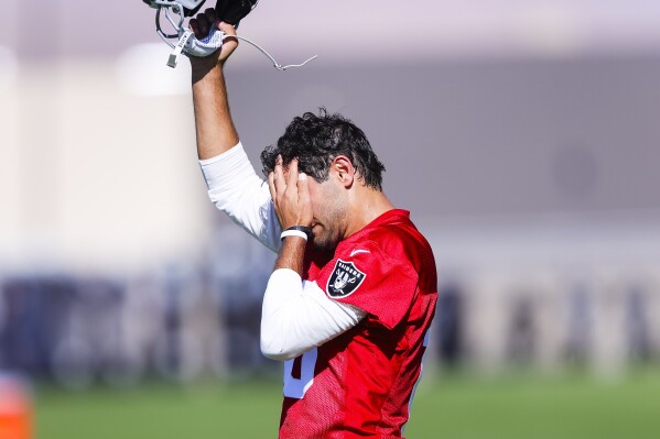 Las Vegas Raiders quarterback Jimmy Garoppolo wipes away sweat during NFL football practice in Henderson, Nev., Wednesday, July 26, 2023.(Wade Vandervort/Las Vegas Sun via AP)