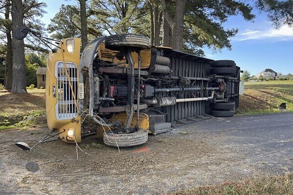 This image provided by Suffolk Fire Rescue shows a school bus that overturned, Monday, Oct. 16, 2023 in Suffolk, Va. Moore says the driver and children were taken to hospitals with minor injuries. School personnel notified the parents of the students involved. (Suffolk Fire Rescue via AP)