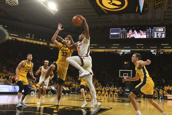 Illinois guard Terrence Shannon Jr. (0) drives to the basket under pressure from Iowa forward Owen Freeman (32) during the first half of an NCAA college basketball game, Sunday, March 10, 2024, in Iowa City, Iowa. (AP Photo/Cliff Jette)