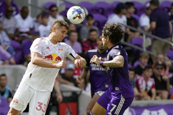 New York Red Bulls midfielder Aaron Long (33) heads the ball past Orlando City forward Alexandre Pato (7) during the first half of an MLS soccer match, Sunday, April 24, 2022, in Orlando, Fla. (AP Photo/John Raoux)