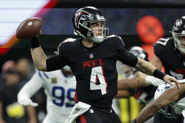 Atlanta Falcons quarterback Taylor Heinicke (4) works in the pockets against the Indianapolis Colts during the first half of an NFL football game, Sunday, Dec. 24, 2023, in Atlanta. (AP Photo/Alex Slitz)