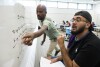 George Mason Term Instructor Ermias Kassaye, left, helps a student figure out an equation during a summer math boot camp on Thursday, Aug.  1, 2023 at George Mason University in Fairfax.  Va.  Researchers say math learning suffered during the pandemic for various reasons.  An intensely hands-on subject, math was hard to translate to virtual classrooms.  (AP Photo/Kevin Wolf)