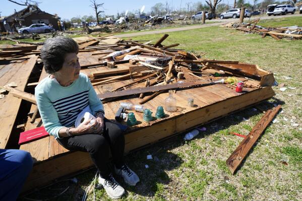 Robbie Diffey sits on top of the roof of her garage after a tornado destroyed the home she's lived in for 38 years, Monday, March 27, 2023, in Rolling Fork, Miss. (AP Photo/Julio Cortez)